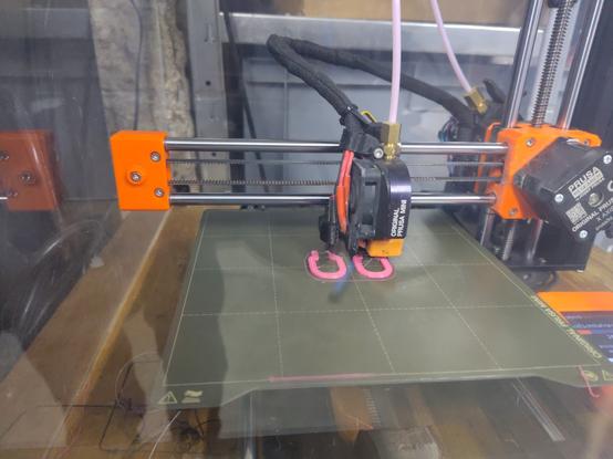 Ein 3 D Drucker druckt mit rosa Filament.