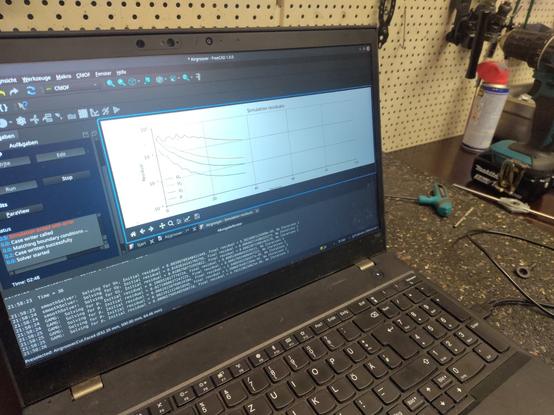 Ein Laptop steht auf einer Werkbank. Es läuft ein Analyse Programm und es werden 4 Kurven erzeugt.