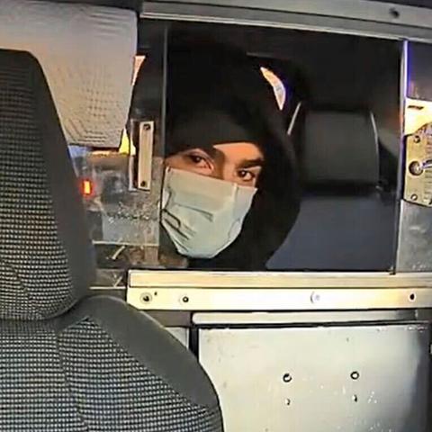 In an image released by the Police Department, the suspect in the killing of Brian Thompson is seen in the back of a taxi on the morning of the shooting.