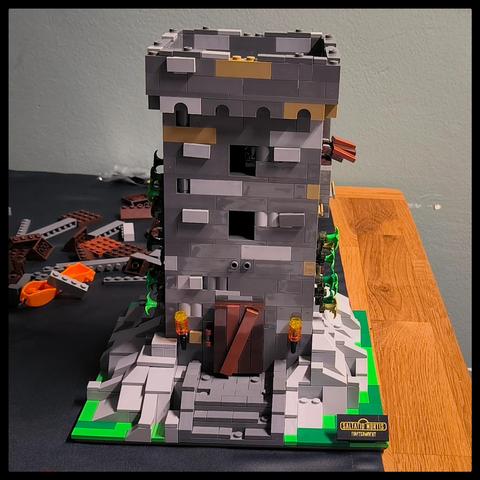 Ein sich im Zusammenbau befindlicher Turm aus Klemmbausteinen steht auf einem Tisch. Im Hintergrund liegen weitere Klemmbausteine herum.