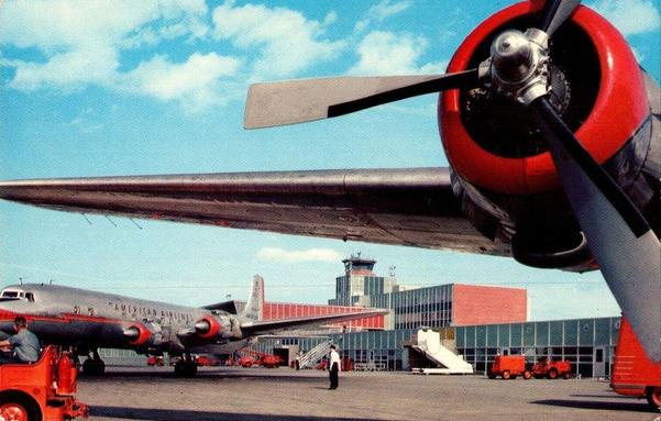 The view is with your back against the fuselage of the DC-6.  You are looking back, almost under the wing. Above is one of the large piston engines and the wing. To the left is the DC-7, Flagship District of Columbia. In the back is the terminal and tower.