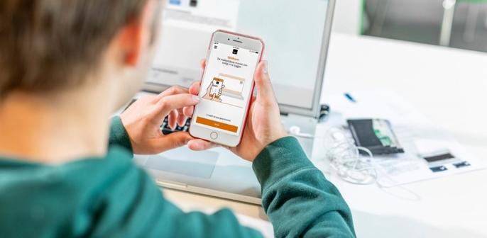Foto van een ouder die op zijn smartphone inlogt in zijn DigiD