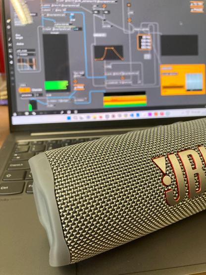 Photograph of a bluetooth speaker and a laptop computer running a Max/MSP patch