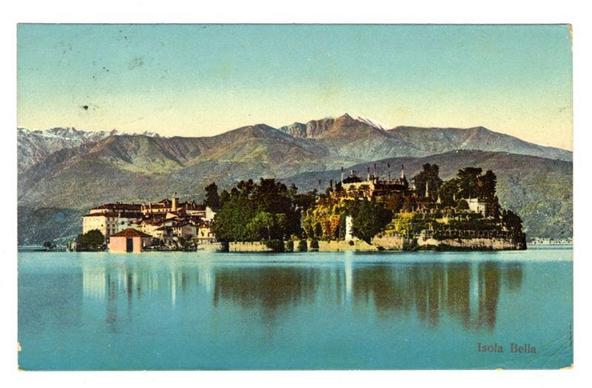 The image depicts a picturesque view of the island known as "Isola Bella" located in Lago Maggiore, Italy. The scene captures a clear day with calm blue waters reflecting the sky and mountains beyond. In the foreground, we see an expansive lake that reflects its surroundings almost perfectly.

Centered on the water is Isola Bella, which appears lushly green with well-maintained gardens, buildings of various sizes including what looks like a grand mansion or palace, and other structures possibly serving as residences or facilities for visitors. The architecture suggests European influences, likely from historical periods given their ornate design elements.

In the background are majestic mountains, covered in patches of snow on higher elevations, indicating that this location is not only picturesque but also situated at an elevation where temperatures allow for such a phenomenon to be visible during certain times of year or seasons. The sky above has a soft blue hue with minimal cloud coverage, enhancing the serene and tranquil atmosphere.

The overall composition exudes a sense of peacefulness and beauty typical of European lakeside landscapes. It is likely that Isola Bella serves as both a historical site and tourist attraction, offering visitors scenic views across Lago Maggiore from this vantage point on the island. The image captures not just the physical aspects but also hints at an experience rich in history and na [...]