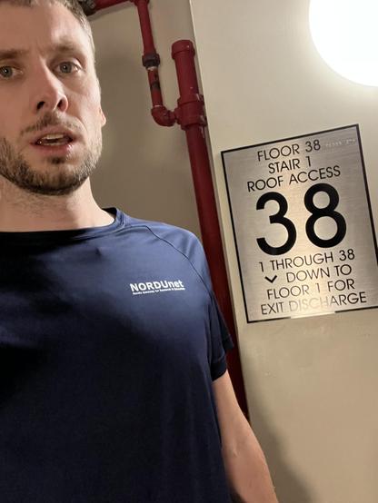 Me catching breath after running the stairs to the top floor. Sign on wall stated floor 38.