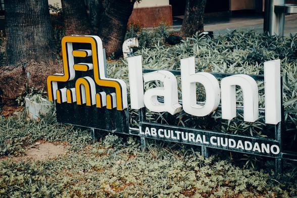 Foto a color, exterior. Logo del LabNL colocado a la entrada de la sede.