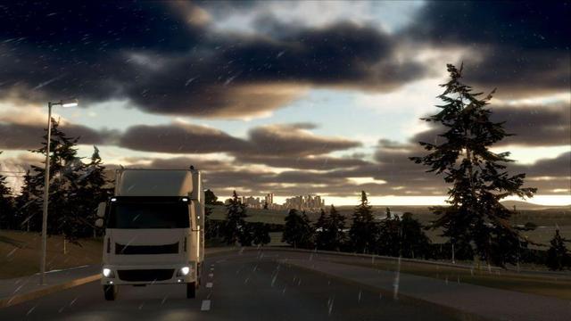 A truck running up a road, seen from the front. Behind it, raised train tracks and way behind the skyline of a high rise city.