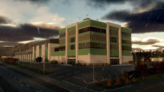 A logistic building in white and green, with a parking lot in the front.