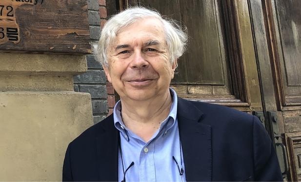 Prof. Guy Brasseur in front of a wooden door which belongs to a museum in Shanghai.