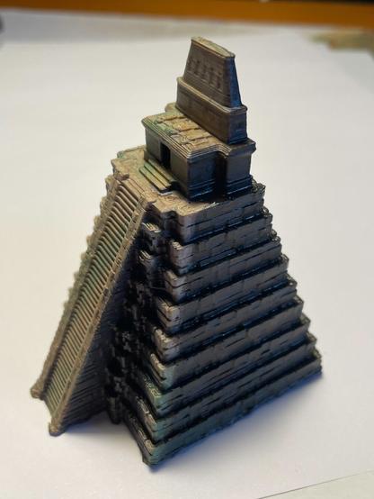 Miniatura impresa en 3d y pintada a mano del templo del Jaguar en Tikal (Guatemala). La foto lleva luz cenital por lo que las luces y sombras que se aprecian son producto de la pintura y no de la iluminación. Foto en semipicado tres cuartos por la cara en sombra. Desde este ángulo se aprecia la esquina del templo iluminada aunque ambas caras estén oscuras (una por dar la espalda a la luz y otra por la sombra proyectada por la escalinata).