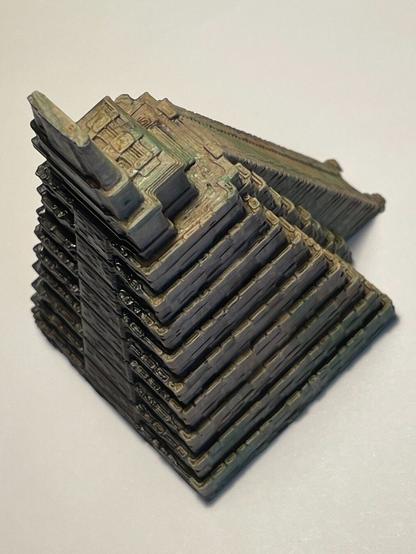 Miniatura impresa en 3d y pintada a mano del templo del Jaguar en Tikal (Guatemala). La foto lleva luz cenital por lo que las luces y sombras que se aprecian son producto de la pintura y no de la iluminación. Foto en picado diagonal entre la zona iluminada y la oscura.