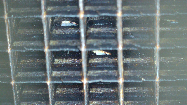 A view from the plywood grid of the matrix (used to separate the leds to make a clean display).
A bout 3 x 5 cells are shown. We can see at holes in at least 3 'walls' separating cells.