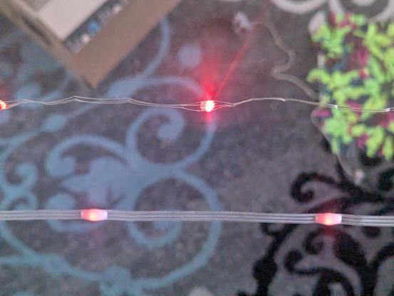 Two strings of neopixels above a carpet. 

The string in the top of the picture is the first generation. It is individual coated wires for 5V, GND and DATA which are very prone to tangling, kinking, snagging and if you're unlucky, breaking.

The bottom string is the new style with the wires enclosed in silicon like a ribbon cable and better silicon protection around the individual bulbs. They are a little more diffuse and not quite as 'sparkly' as the originals when lit.