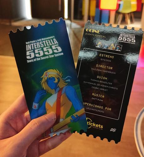 Two special tickets for the "Interstella 5555" movie depicting Arpegius, a blonde, blue-skinned guitarist with an orange and white top, and some names of personnel from the movie.