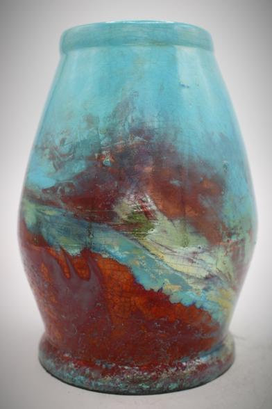 A light blue raku vase with red and golds
