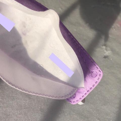 Close-up photo of some condensation (water droplets) inside a lavender-coloured KN95 face mask.