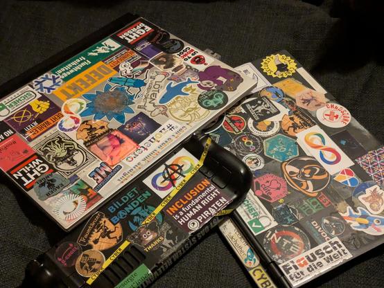 A Steam deck and two Laptops with a bunch of stickers.