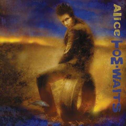 The cover art seems to be between a photo and a painting, as the coloring (sepia/yellows and blues) and smudging/blurring make it look surreal. The artist is sitting on an upended car tire, his body facing what looks like a field but his head turned to look at the camera/painter. A fish is swimming by his leg, in mid-air. The album name is in a yellow font, written on its side from the top right corner down, and the artist's name is in blue font directly underneath, almost reaching to the bottom right corner.