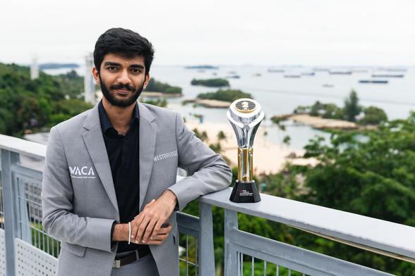 Gukesh D with the FIDE trophy in the foreground and the Singaporean coast in the background.

Photo by: Eng Chin An