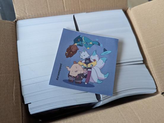 A box full of stickers with one sticker laying on top, with an artwork tihyltew made, of the corteximplant.com mascots hanging out together with the Kitsune mascot.

Hangaku (the Kitsune mascot) is leaning on John Cyberdon (the corteximplant.com mascot) who isn't looking all that happy about it, while Ramona (the corteximplant.net mascot) is floating above them