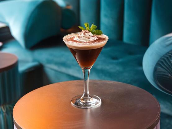 Peppermint Mocha Martini with whipped cream and mint sprig garnish
