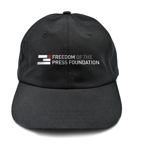 A black baseball cap with the Freedom of the Press Foundation logo and name printed on it