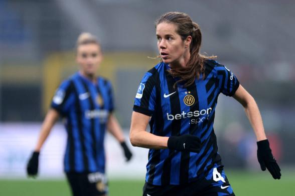 Sofie Junge Pedersen im blau-schwarz gestreiften Trikot von Inter Mailand in der Laufbewegung, sie schaut zum linken Bildrand. Im Hintergrund ist Mitspielerin Lina Magull unscharf zu erkennen.