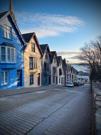 The Deck of Cards in Cobh, Co. cork - colourful houses with steeply pitched roofs line a sloped street.