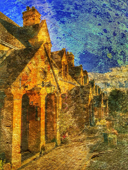 A row of terraced cottages on left, with shared double door porches with triangular gables. Dormer windows and chimneys. Path in front and gardens to right. Textured with lichen covered limestone ball finial.