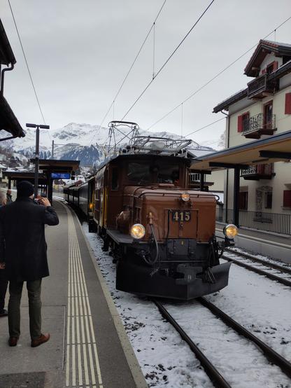 Foto. Ein grüner Zug mit brauner Lokomotive Nr. 415 im Bahnhof.