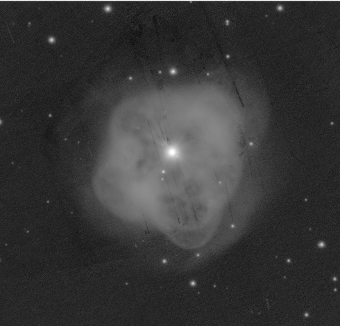 A vaguely round, blobby nebula with a bright star in the center. It's the brightest star in the image. There are some hints of texture in the nebula, like places which seem more hollow than others, like a very misshapen bubble. There are many straight lined cosmetic defects in the image which are obviously not real. They are distracting. Various dimmer stars also dot the image.