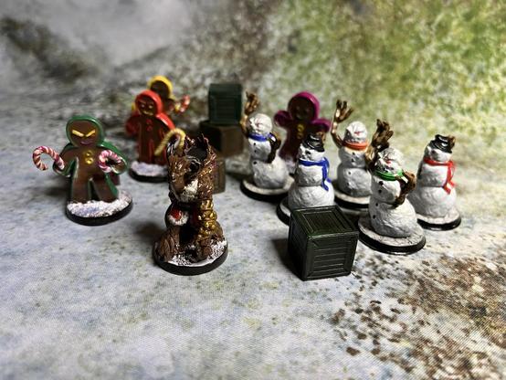 Eine Anzahlung von Minis auf einem Schneefeld: vier Lebkuchen-Menschen , fünf grimmige Schneemenschen und ein Krampus bewachen einige Kisten.