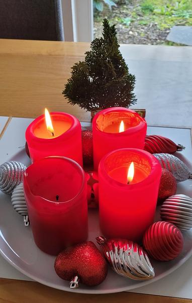 Adventskranz mit drei leuchtenden Kerzen und ein mini Weihnachtsbaum. Three candles are the symbols of the third Christmas week, and there is also a portable Christmas tree.