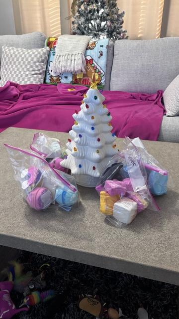 A photo I took of the bath bombs from Lush that I got my wife as a Christmas present. You can see the ceramic Christmas tree with them, the coffee table they are sitting on and the couch in the background that has a couple of blankets on it.