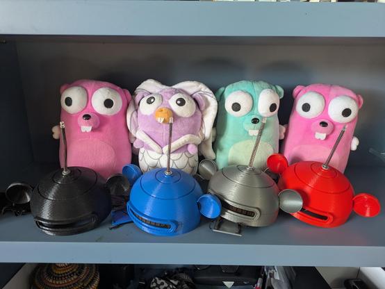Four Gopherbot robotic gopher plushies sitting on a shelf.