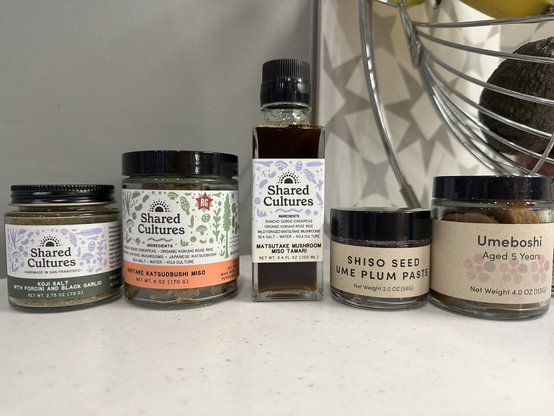 A photo of the condiments listed in the post, plus a Shared Cultures umami salt, on our kitchen counter.