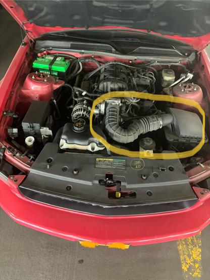 A Before picture of my V6 ‘06 Mustang 4.0L with the stock air intake circled.