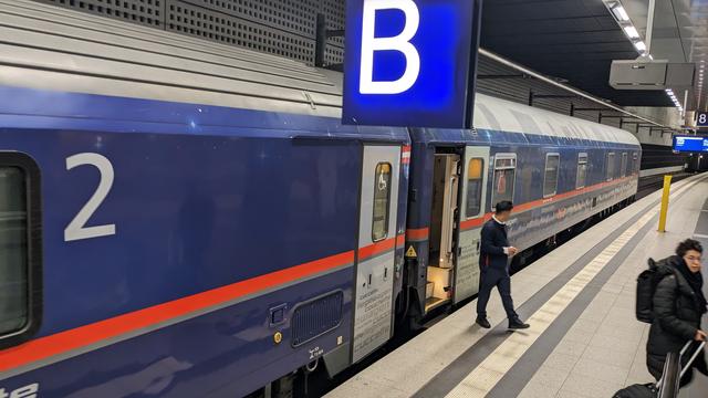 A nightjet with a modernized couchette carriage and a classic sleeper carriage visible at the end of the train standing in Berlin Hbf.