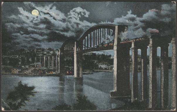 Printed colour postcard showing a moonlit view of the Royal Albert Bridge between Saltash in Cornwall and Plymouth in Devon.
Published by Valentine & Sons Ltd, Dundee & London, Valentine's Moonlight Series, not numbered.
Postally used on 3 October 1904 with squared circle Plymouth cancellation on green halfpenny stamp and sent to Miss Francis Webster, Trevenson Street, Opposite Public Hall, Camborne, Cornwall.
Good condition, with slight corner bumps, but small crease to bottom left corner.