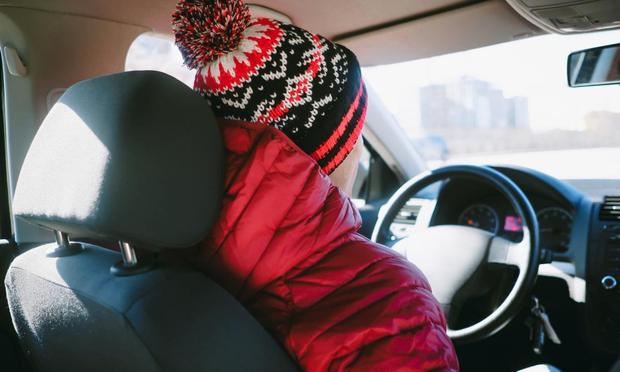 Una persona, en el coche con el abrigo puesto. (GETTY)