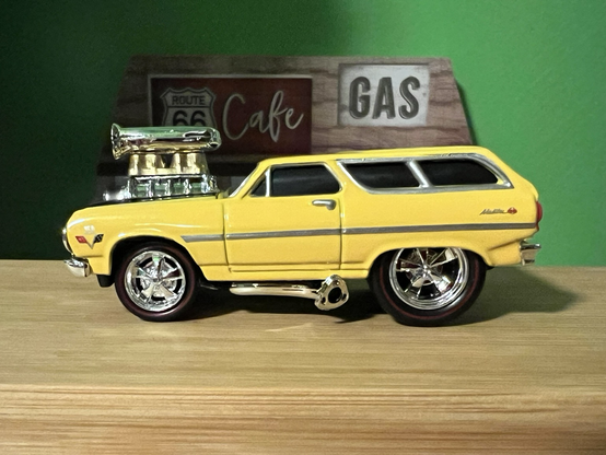 A yellow 1965 Chevy Chevelle station wagon toy made by Muscle Machines