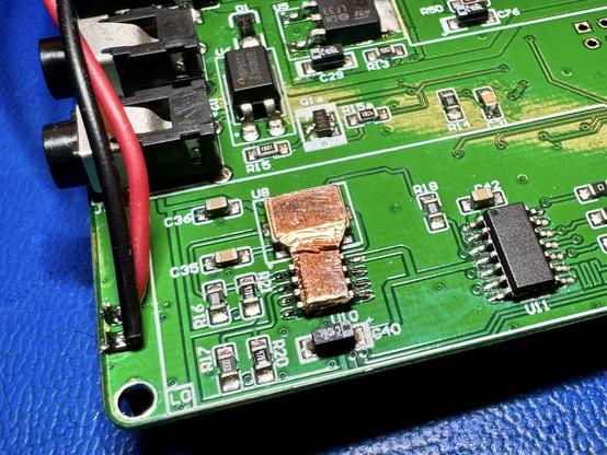 The mcHF RF board with an SO-8 Temperature sensor soldered on. There is a copper tape shape bridging across from the SO-8 To the square oscillator package.