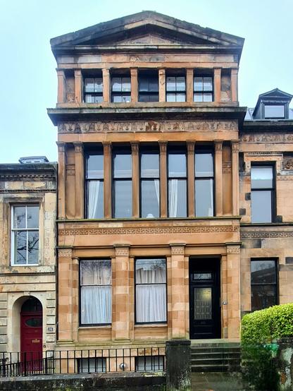 A tall, narrow Classical style Victorian townhouse.