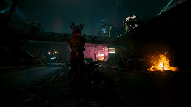 My second V. shown from behind.
It's night.
She is positioned in the middle in front of a motorcycle, her red outfit looks very dark thanks to the light, wearing sort of a mechanical winged crown on her head, her left Arm rests over her belly, the hand resting on her right elbow. She smokes a cigarette. On the right a trashpile fire is burning in the dark.
Between V. and that fire 2 palm trees are illuminated by neon red, horizontal lights that barely manage to show the ruble on the street. A brigce crosses to both sides close behind V. On the hight of her shoulders slightly tilted upwards to the left of the picture.
It cuts the picture into up an down sections, while V. cuts it into left and right. The upper section is cold bluish and foggy, on V.'s left side a broken neon light is visible, a red heart and above the word Heaven, in yellow upper case letters, missing an E.