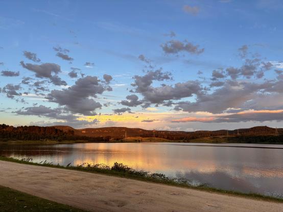 Scenes showing the sunset tonight blue sky and fiery orange lighting up the clouds and reflecting on the lake below .