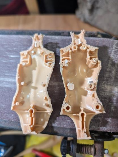 The inside two halves of the body (neck to crotch) torso of a very cheap Barbie doll. It's been cut apart along the sides, and the interior has a whole array of molded in pins and sockets that, when glued (or perhaps sonic welded), hold the two halves of the body together.