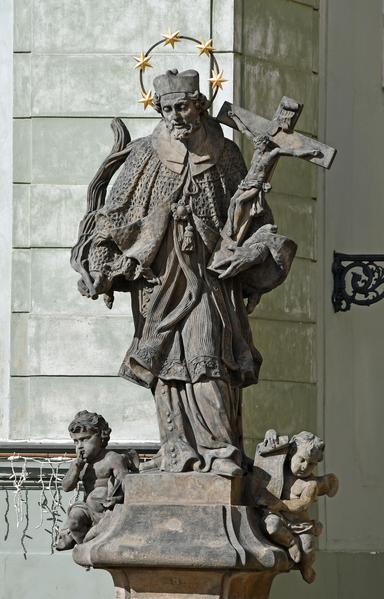 the saint holds a large crucifix in one hand and a branch in the other while cherubs sit by his feet and his head is surrounded by his signature halo of five stars