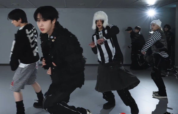 Stray Kids dance practice. At the rear of the practice studio, Bang Chan has captured Seungmin in an arm-pinning backhug