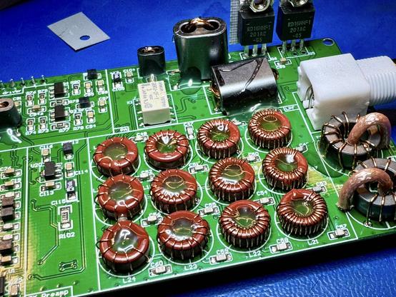The mcHF RF board. The Toroid inductors have a big blob of hot glue melted into the center hole. The glue goes all the way down to the PCB keeping them in place. On the right the SWR/Power meter inductors have also a small dab of hot glue on the side. In the background the transformers also have some hot glue to keep them in place.
