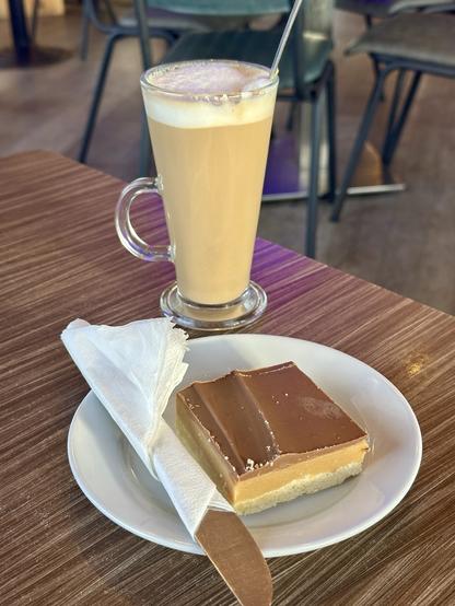 A latte in a glass cup with a millionaire bar at Coast Café & Gifts on the Promenade in Llandudno